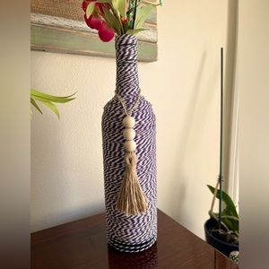 Bottle wrapped with purple twine.